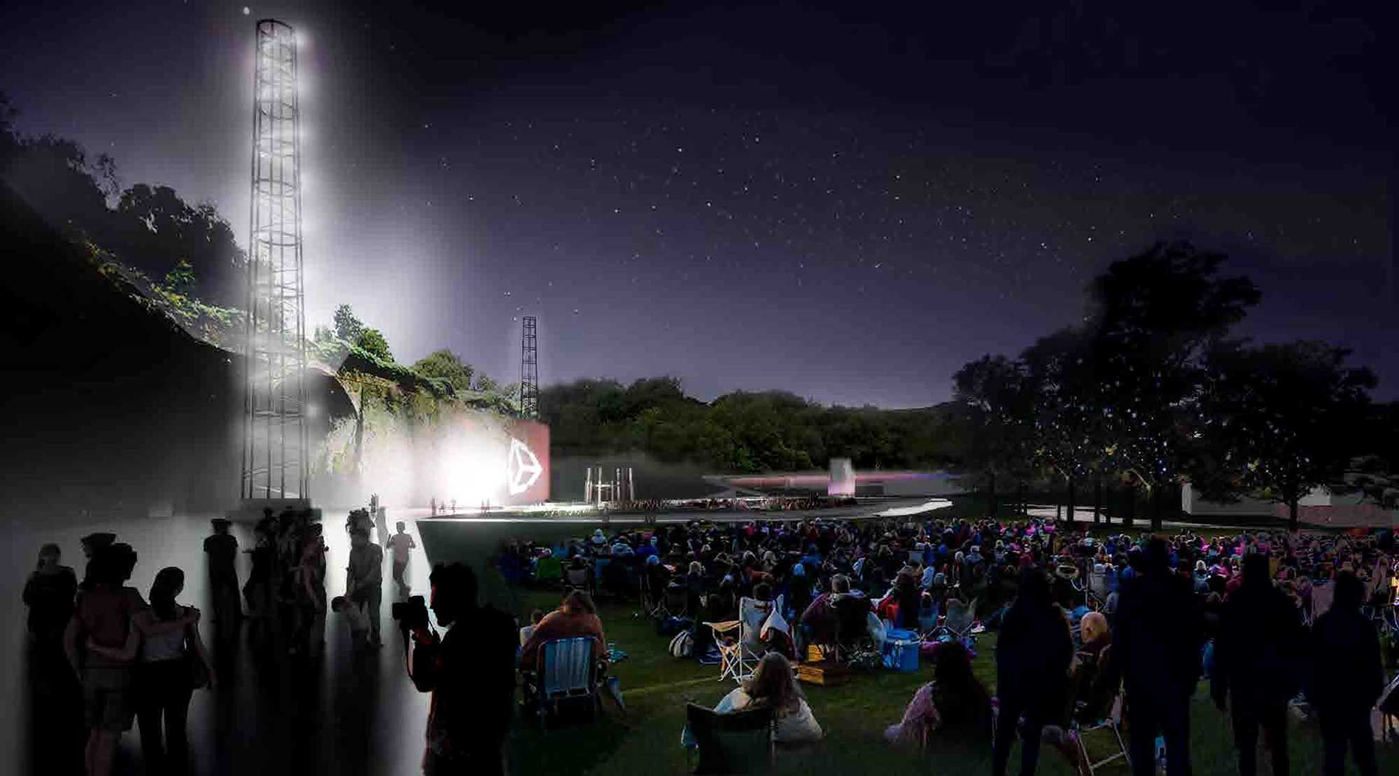 People sat in a field watching a bright stage at night.jpg