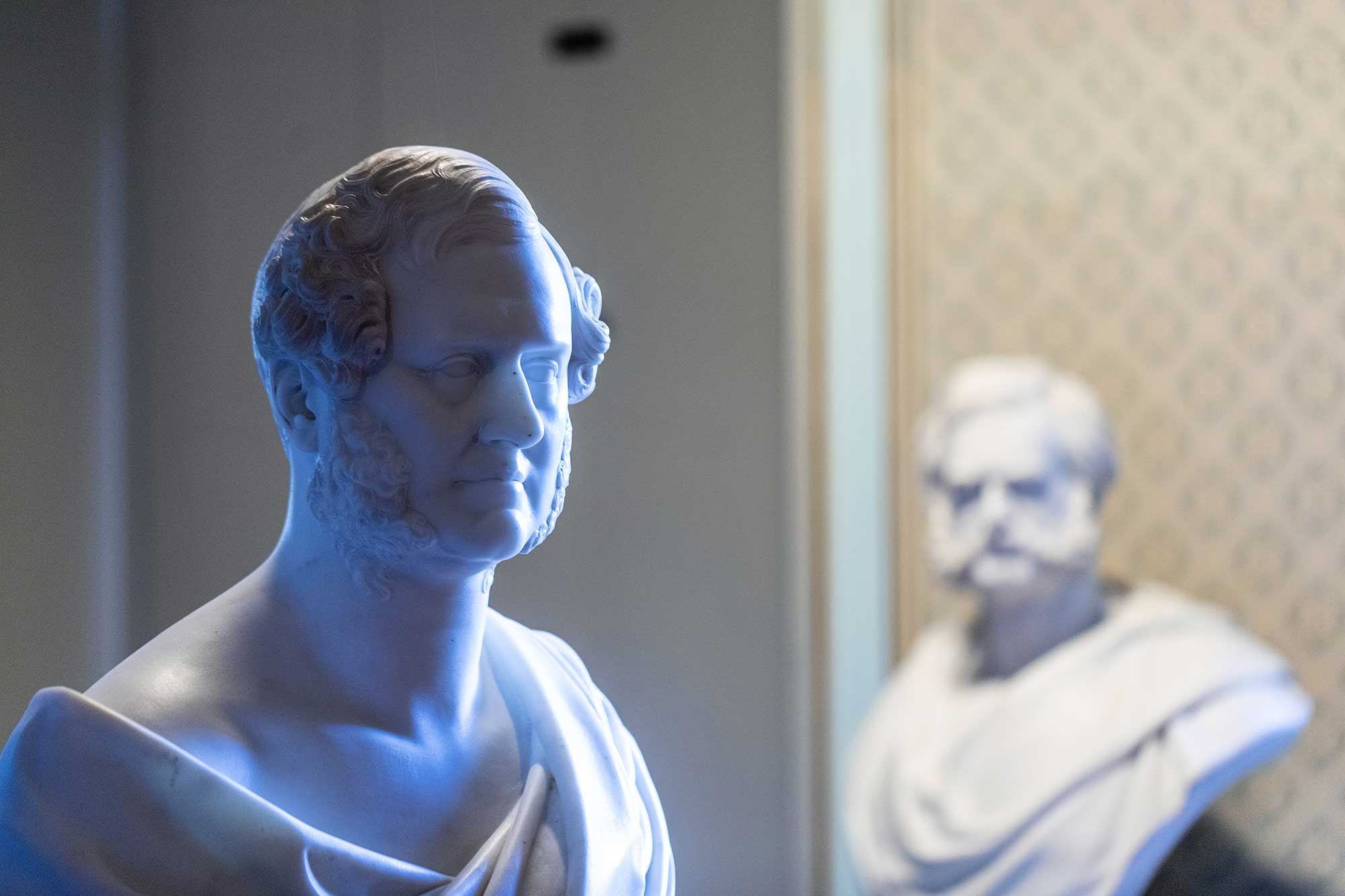 White marble bust of a man with short hair and sideburns.jpg