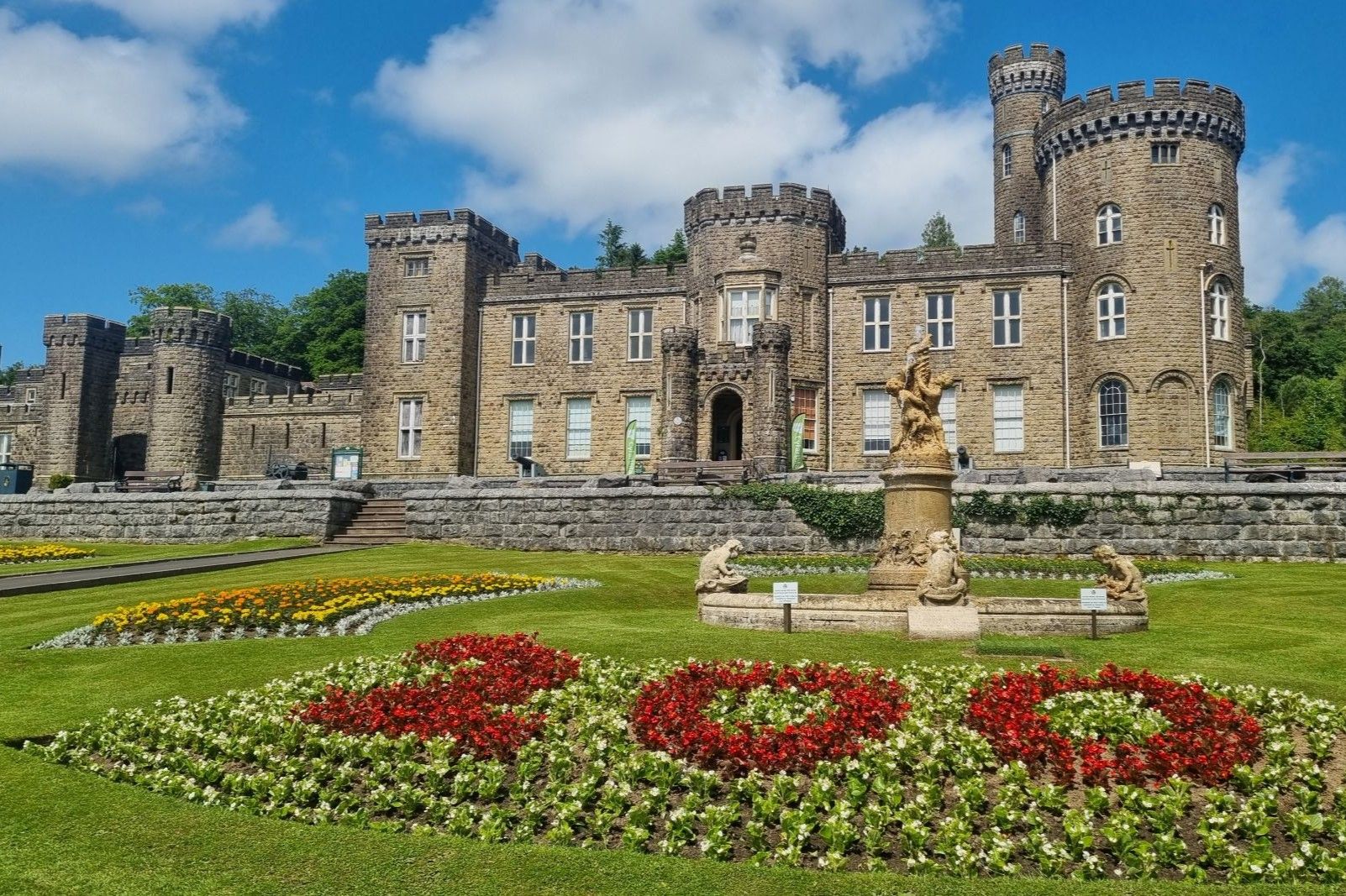 Cyfarthfa Castle with 200 in red flowers in the foreground..jpg