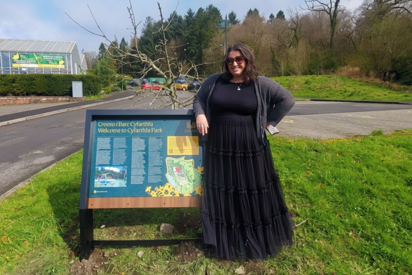 CEO Jess Mahoney stood alongside the new signage in Cyfarthfa Park.jpg