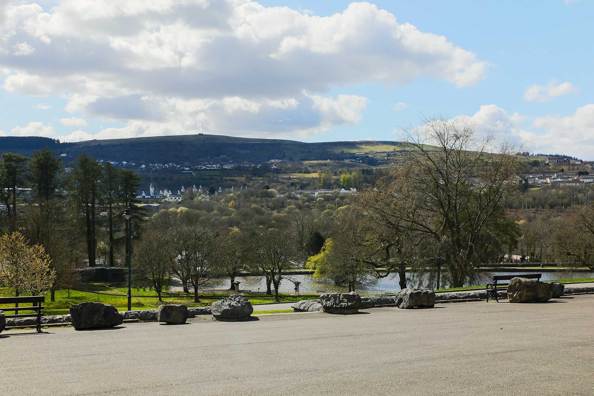 View of trees, large boulders, a lake and hills in the distance.jpg